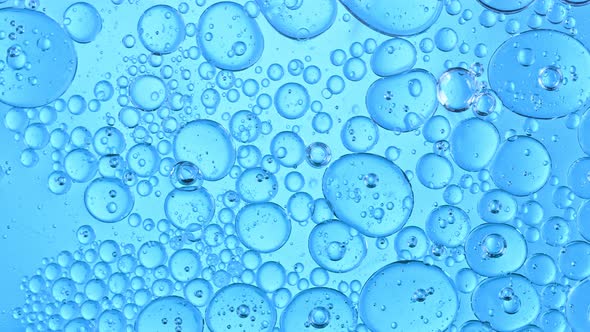 Super Slow Motion Shot of Moving Oil Bubbles on Blue Background at 1000Fps