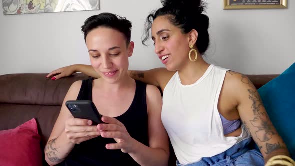 Lesbian couple using smartphone at home