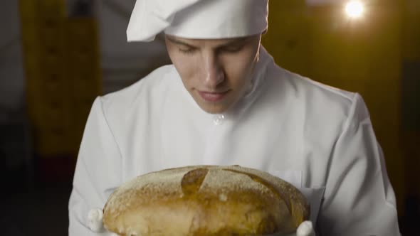 Baker Uniform Sniffs Loaf Bread Has Pleasure Smile Camera