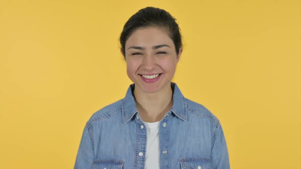 Indian Woman Smiling at Camera Yellow Background