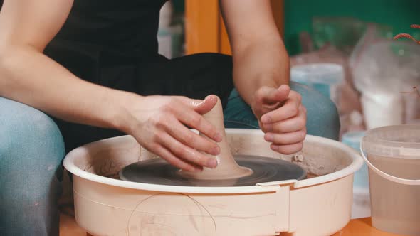 Pottery - the Master Is Pouring Elongated Clay with Water and Continuing Modeling