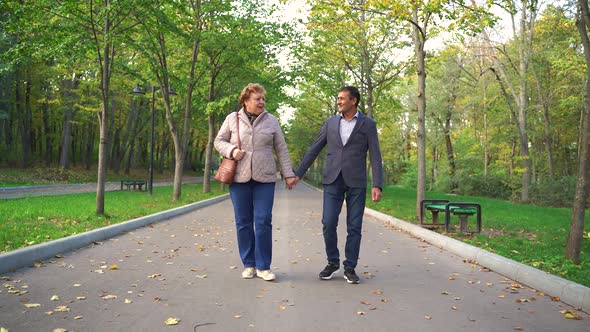 Mature Couple Walking and Talking on Autumn Day