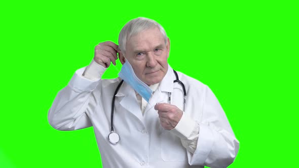 Old Doctor Putting on Medical Mask.