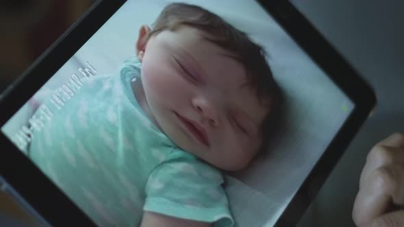 Slow Motion of Woman Moving Baby Monitor Through Tablet