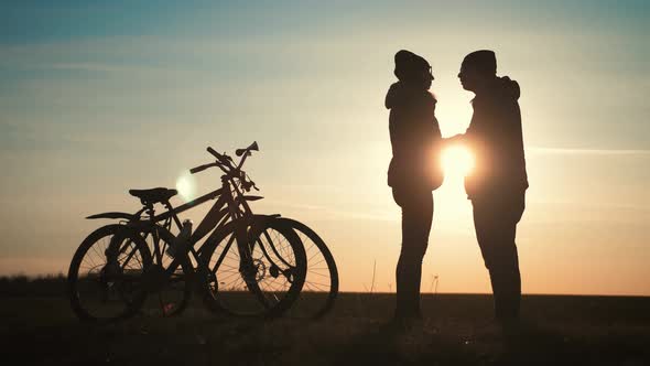 Couple Silhouettes of Cyclists on a Sunset Time. alt