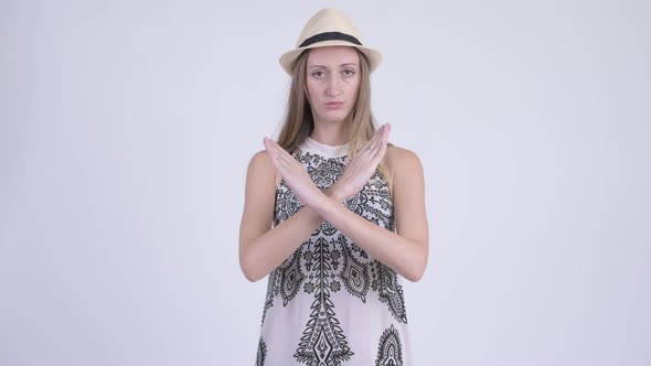 Portrait of Stressed Blonde Tourist Woman Showing Stop Gesture Using Arms