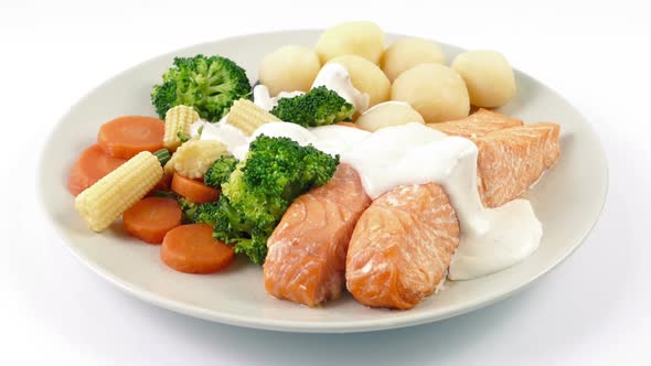 Sauce Poured On Meal Of Salmon, Potatoes And Vegetables