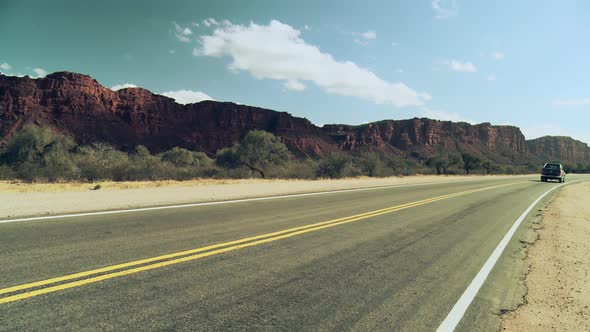 A Pickup Truck driving on a Rugged and Arid Landscape. 4K Version.