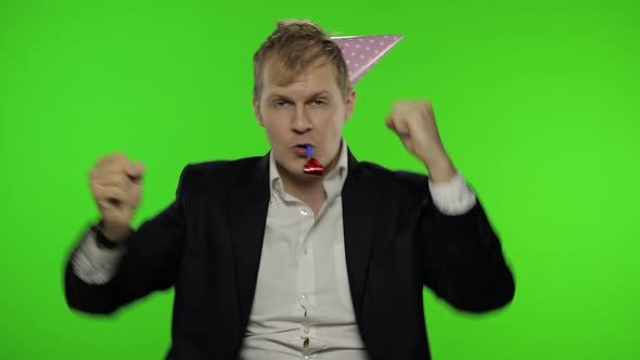 Drunk Disheveled Young Businessman in Festive Cap Celebrates and Dances