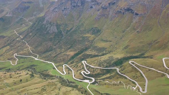 Long winding mountain road in the Dolomites of northern Italy, Aerial drone dolly-in reveal shot