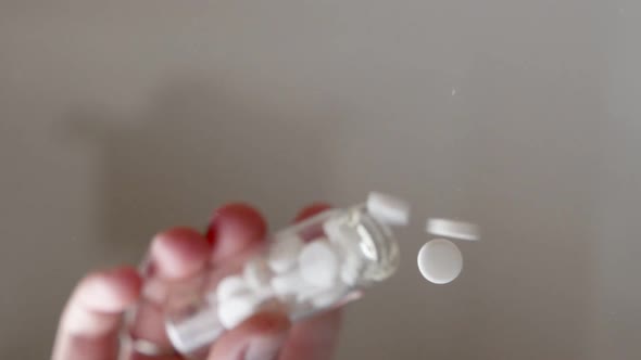 White Prescription Pills Fall Directly Onto the Lens in Slow Motion. The Pain Killer Tablets