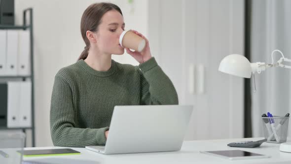 Young Woman Drinking Coffee at Work and Having Toothache