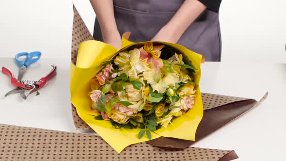 Packing Bouquet. Florist Wraps a Bouquet of Paper. White. Time Lapse. Close Up