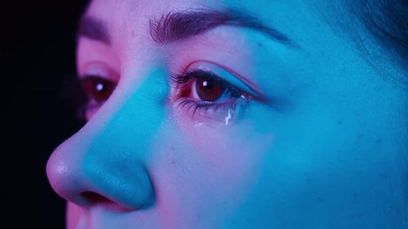 Closeup of Crying Brown Eyes in Ultraviolet Light Side View of Watery Eye of Young Woman Shooting of