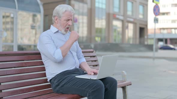 Coughing Old Man Using Laptop While Sitting Outdoor on Bench