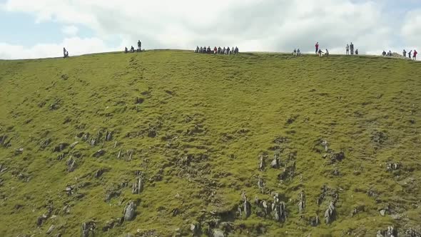 Aerial drone footage of people sitting on top of mountains in the Lake District, England.