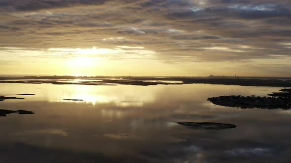 An aerial shot over Baldwin Bay near Freeport, NY at sunset. The camera truck left facing the sun as