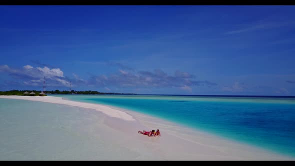 Family of two relax on exotic coast beach vacation by blue water and white sand background of the Ma