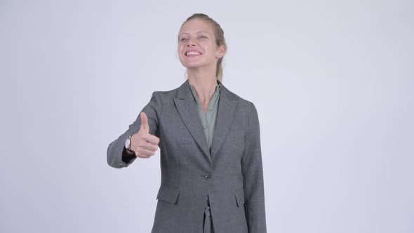 Young Happy Blonde Businesswoman Giving Thumbs Up