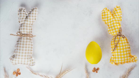 Stop Motion Easter Video of Yellow and Beige Handmade Bunnies Pushing Yellow Easter Egg to Each