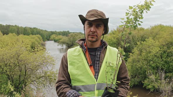 Man with Seedlings in Forest