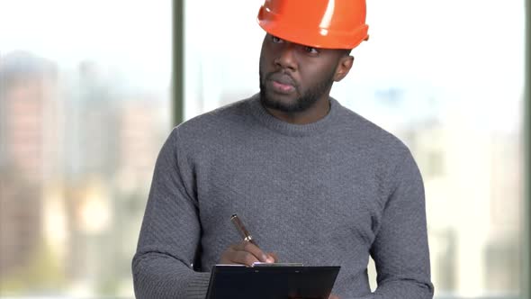 Afro American Architect Writing Down Notes on Clipboard.