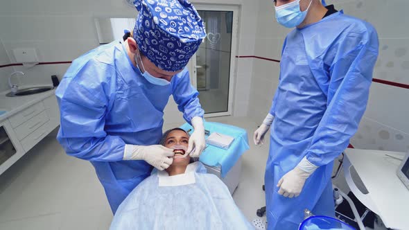 Dentist Preparing Female Patient For Dental Treatment