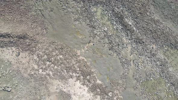 Top-down ascending drone view of rocky beach in St. Martin's island