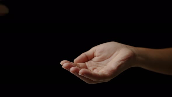 Close up of man hand putting a gold bitcoin into woman hands.