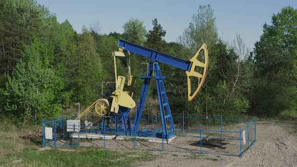 Industrial Oil Pumpjack At Work Pumping Crude Oil With Drilling Rig In Oilfield Near Campina In Roma