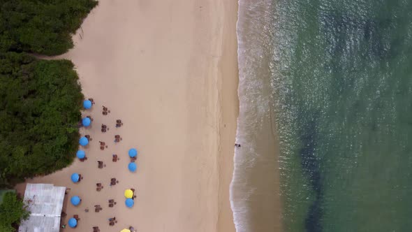 Peaceful scene of green sea waves on beach sand. Aerial birdseye, dolly forward