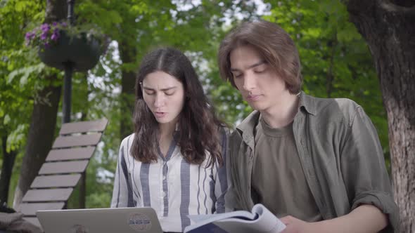 Portrait Cute Couple Spending Time Together in the Park, Studying. The Male and Female Students in