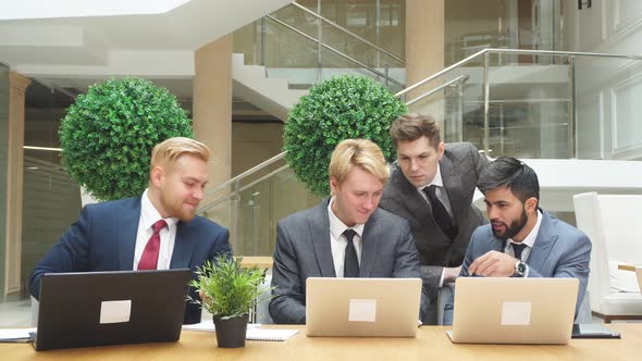 Group of Multi National Young Men Looking at Laptop While Discussing New Project, New Deal.