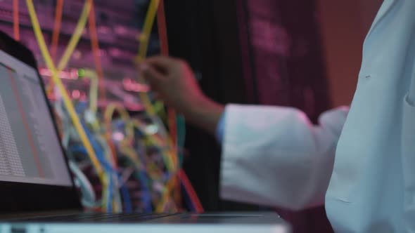 African american male computer technician using laptop working in business server room