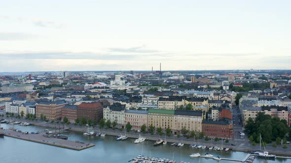 Slow aerial pan of buildings along the Helsinki waterfront at dusk, Finland.