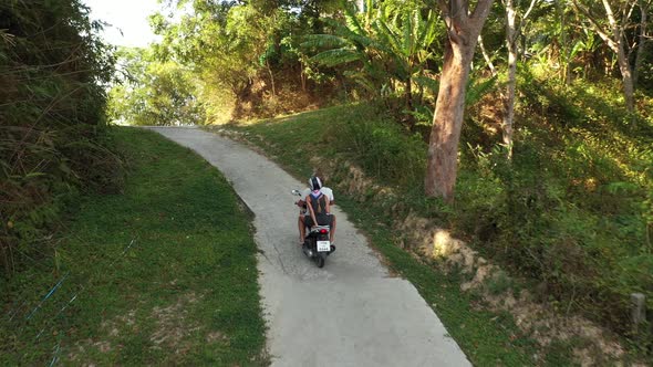 Couple of European Man and Woman in Helmets on Motorcycles Ride Along the Road