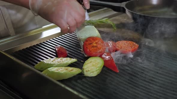 Closeup of the Restaurant's Chef Grilling Vegetables Tomato Zucchini Pepper