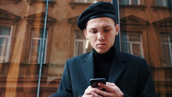 Man Using the Phone in the Street. Young Caucasian Man Texting Messages, Cheating on His Smartphone