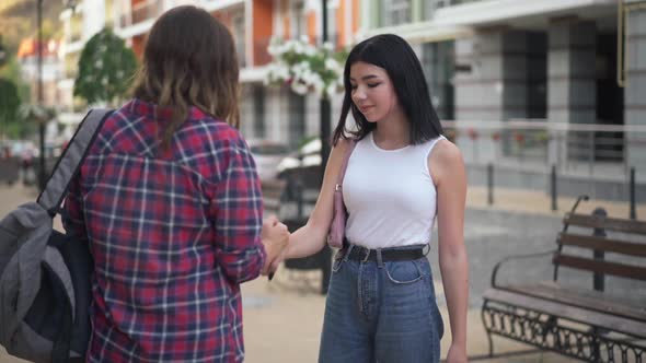 Caucasian Teenage Girls Greeting Gesturing Outdoors Meeting in Urban City