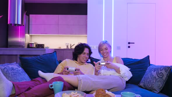 Handsome Young Man Teaching How To Play the Video Games To His Girlfriend, on the Couch, Concept