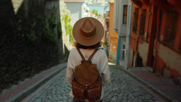 A young girl in a hat standing on a Turkish street in Istanbul