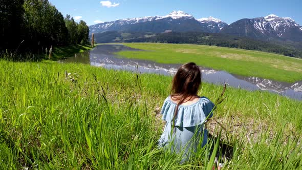 Thoughtful woman sitting in grassland 4k