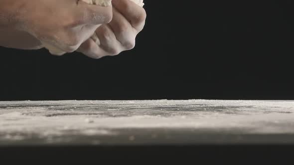 Male Hands Divide Baking Dough Into Shares on a Board Sprinkled with Flour