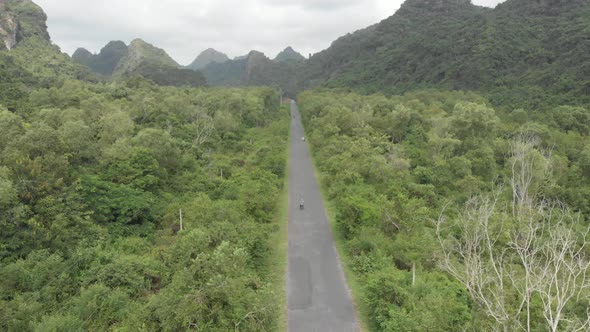 Aerial: people riding scooter inland Cat Ba island, travel destination in Vietnam