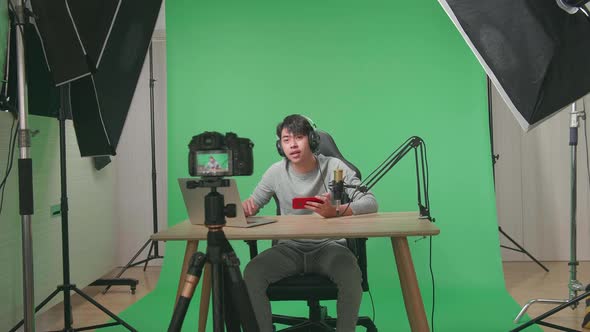 Camera Recording Man Reading Comment On Computer While Playing Game On Mobile Phone On Green Screen