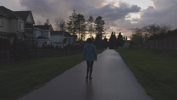 Woman Walking on a Path in a Residential Neighborhood of Modern City Suburbs