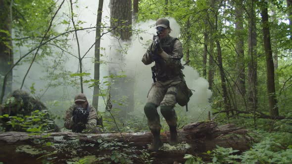 Machine Gunner and Sniper in Camouflage Taking Up Cover Position