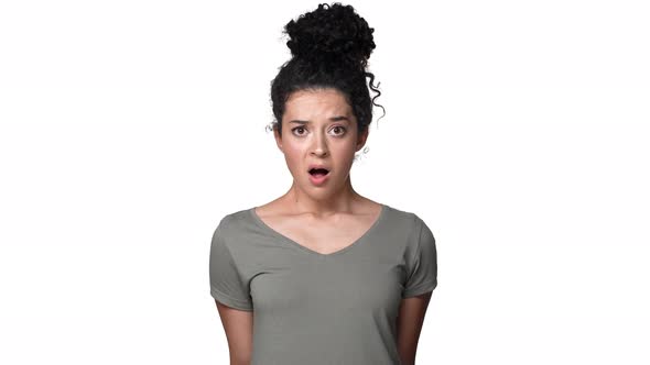 Portrait of Surprised Woman 30s with Curly Hair in Bun Shaking Head and Expressing Unexpectedness or