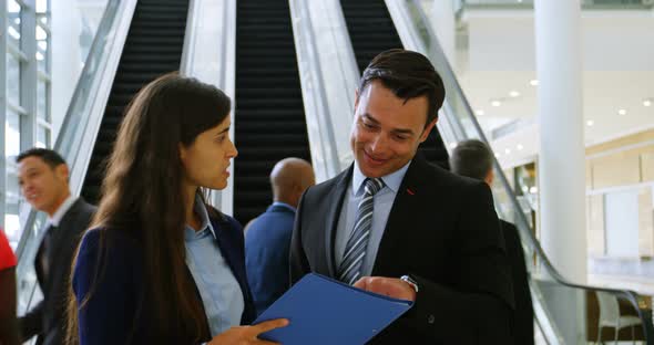 Business people discussing over file