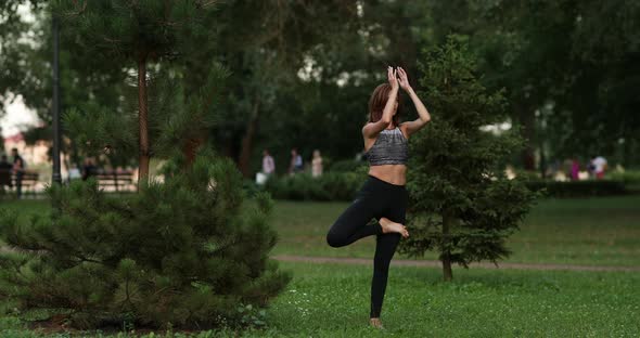 Girl Meditates in Nature. Woman Performs Body Balancing.